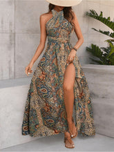 Women maxi dress high waisted cross halter neck with tie, featuring a colorful tropical pattern and a side slit.