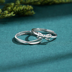S925 Silver Bow Couple Ring displayed on a green surface, perfect fashion jewellery for Christmas.