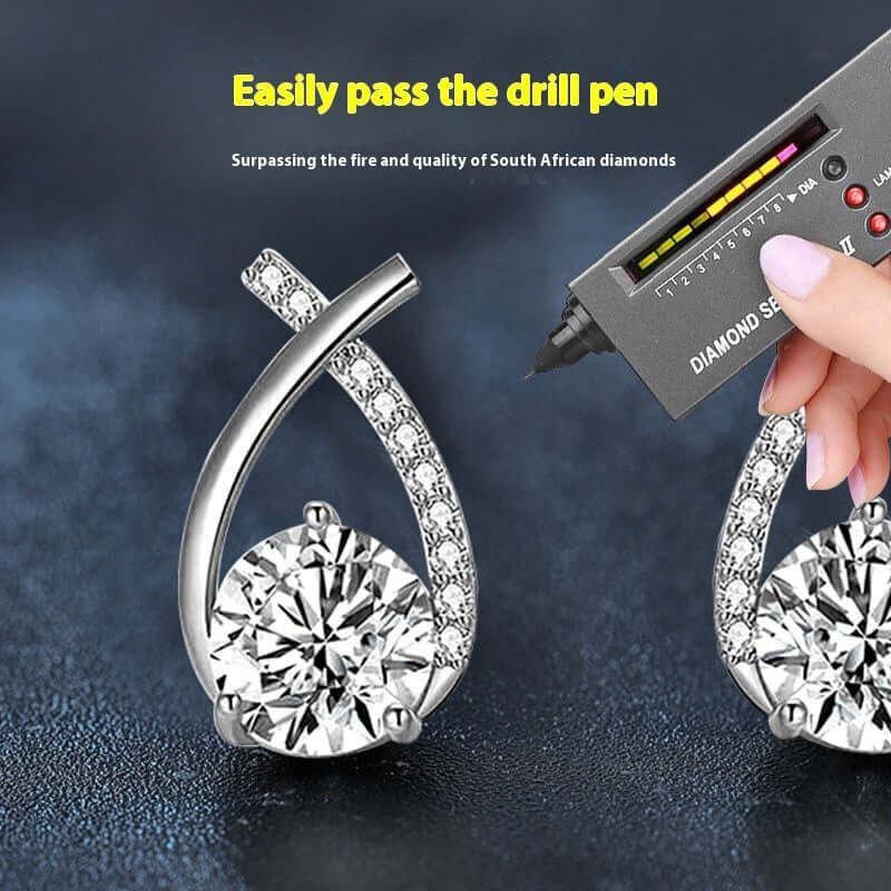 Moissanite 925 Sterling Silver Fishtail Cross Stud Earrings under diamond tester to show quality and craftsmanship.