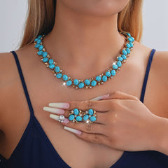 Turquoise Pearl Necklace And Earrings Suite worn by a model showcasing vibrant turquoise stones and rhinestone accents.