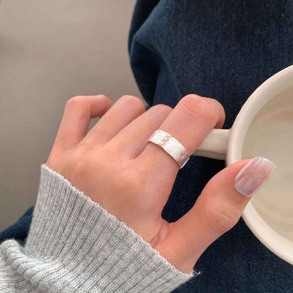S925 Sterling Silver Brushed Pearl Ring For Women worn on a hand near a coffee cup, showcasing its fashion jewellery design.