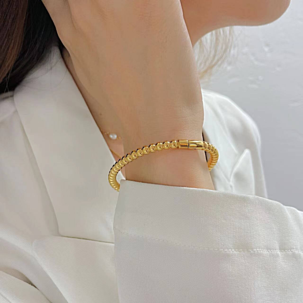 Titanium Steel Round Beads Stainless Steel Bracelet worn by a woman, showcasing its gold electroplated finish.