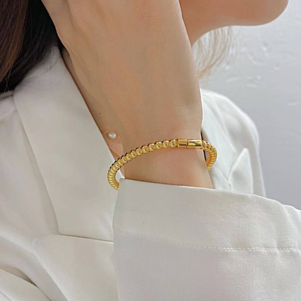 Titanium Steel Round Beads Stainless Steel Bracelet worn by a woman, showcasing its gold electroplated finish.