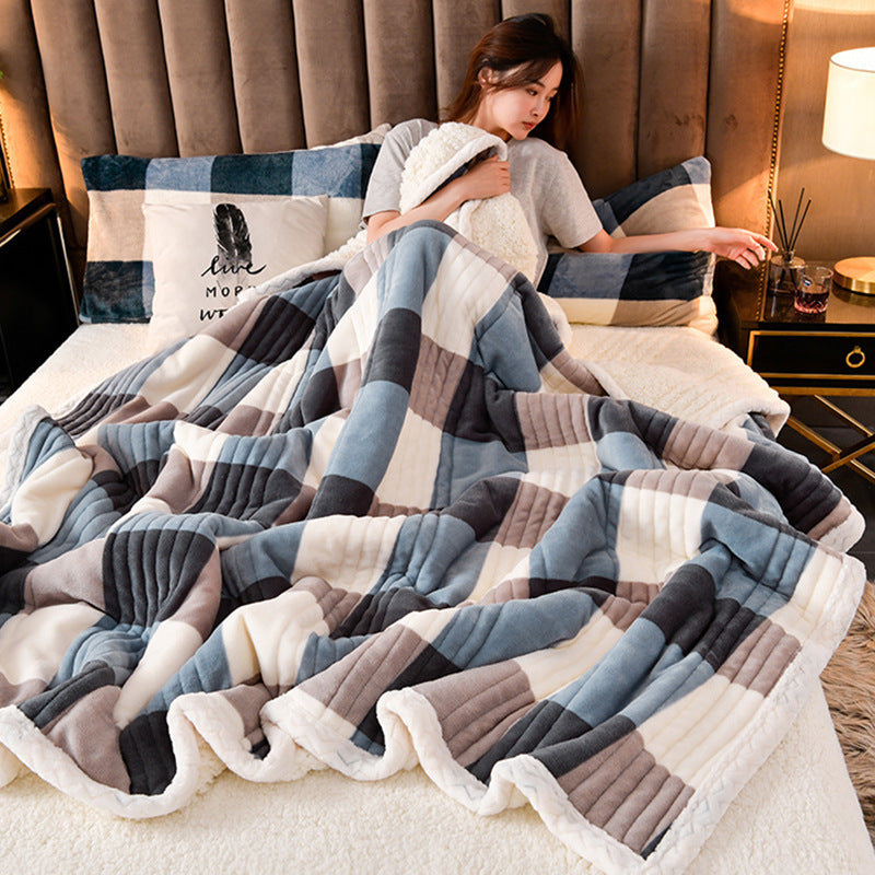 Cashmere Three-layer Blanket Thickened Warm Feather Silk Blanket wrapped around a woman on a bed with decorative pillows.