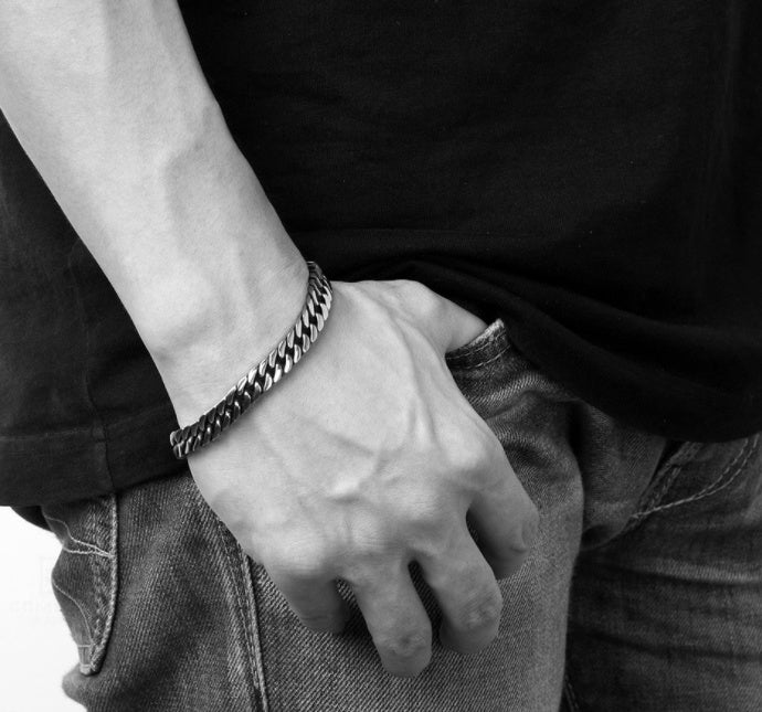 Stylish men's titanium steel bracelet featured on a hand, showcasing geometric design, inlaid with silver.